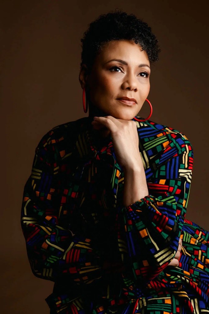 Woman in colorful patterned attire, thoughtful.